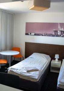 1 dormitorio con 1 cama y 1 mesa con sillas en Aparthotel Strefa Budget en Tychy