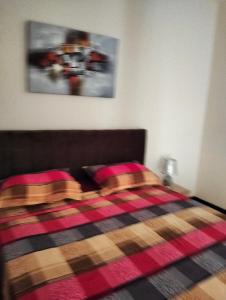 een slaapkamer met een bed met een geruite deken bij 119 camus 120 in Houmt Souk +5 foto's