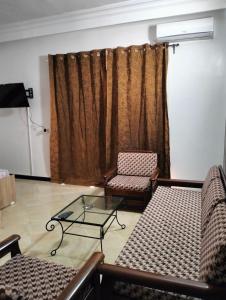 een woonkamer met 2 stoelen en een glazen tafel bij 119 camus 120 in Houmt Souk