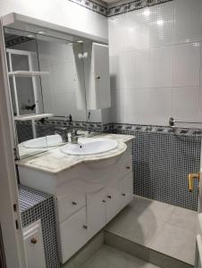 een witte badkamer met een wastafel en een spiegel bij 119 camus 120 in Houmt Souk