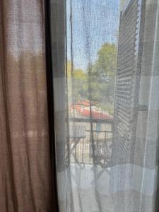 uma vista para um pátio a partir de uma janela com uma mesa em Santa Marina Rooms em Agia Marina Aegina