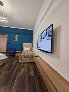 a bedroom with a bed and a flat screen tv at Tirana Daily Rental Apartments 3 in Tirana