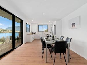 Un comedor y una cocina con mesa y sillas. en Contemporary & Plush - 3 Bedroom House Near Marina, en Queenstown