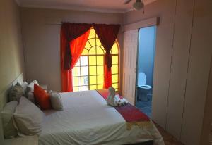 Schlafzimmer mit einem großen Bett und einem Fenster in der Unterkunft Elsje's Country Inn in Kempton Park
