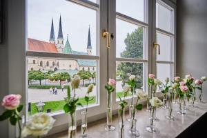 Hotel Zur Post Altötting في آلتوتينغ: نافذة بها مزهريات مليئة بالورود على طاولة