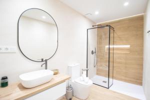 een badkamer met een wastafel en een spiegel bij BedTime Suites by Concept Flats in Valencia
