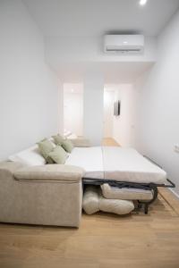 een bed in een kamer met een witte muur bij BedTime Suites by Concept Flats in Valencia