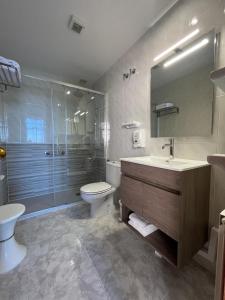 een badkamer met een wastafel, een toilet en een douche bij Hotel Nuevo Lanzada in A Lanzada