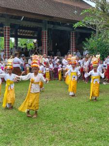 un groupe d'enfants qui dansent devant une foule dans l'établissement Sawitri Anandhita Luxury Villas, à Ubud