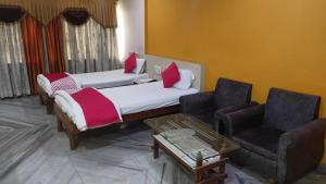 Habitación con 2 camas, sofá y mesa. en HOTEL SHRI KRISHN, en Betūl