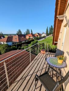 une terrasse en bois avec une table et des chaises. dans l'établissement Apartment Am Horstberg, à Wernigerode