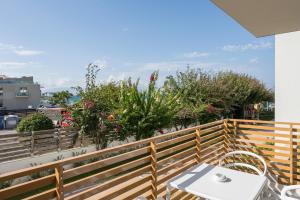 a table and chairs on a balcony with flowers at Ostrakon Suites in Agia Marina Nea Kydonias