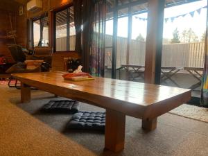 einen Holztisch in der Mitte eines Wohnzimmers in der Unterkunft AKAYA GLAMPING HOUSE - Vacation STAY 41979v in Fukuro