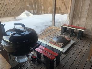 a grill and a pot on a wooden deck with snow at AKAYA GLAMPING HOUSE - Vacation STAY 41979v in Fukuro