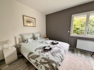 サントーバン・シュル・メールにあるEsperanza Maison & Jardin Merの大きなベッドと窓のある寝室