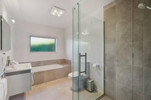a bathroom with a shower and a toilet and a sink at Luxury Retreat - Matakauri in Queenstown +20 photos