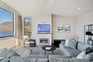 a living room with a couch and a fireplace at Luxury Retreat - Matakauri in Queenstown