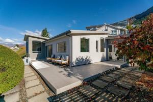 a home with a patio and a house at Luxury Retreat - Matakauri in Queenstown