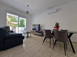 a living room with a couch and a table and chairs at Laertis Apartments -By NOMA STAYS Cyprus in Paphos