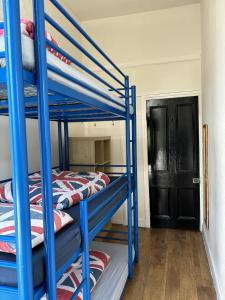 Pokój z łóżkiem piętrowym z 2 łóżkami piętrowymi i drzwiami w obiekcie Saint James Backpackers w Londynie
