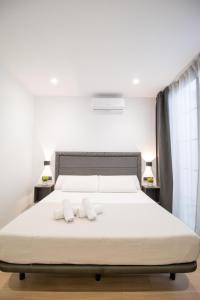 een slaapkamer met een bed en 2 witte handdoeken bij BedTime Suites by Concept Flats in Valencia