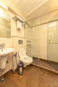 La salle de bains est pourvue de toilettes, d'un lavabo et d'une douche. dans l'établissement Lutyens Bungalow, à New Delhi