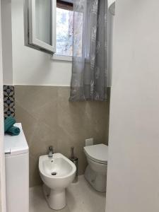 a bathroom with a toilet and a sink and a window at Violetta 1 in Campese +13 photos