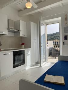 a kitchen with white cabinets and an open door to a patio at Violetta 1 in Campese