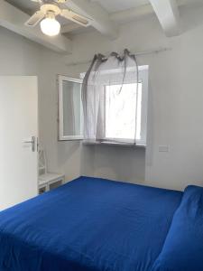 a bedroom with a blue bed and a window at Violetta 1 in Campese