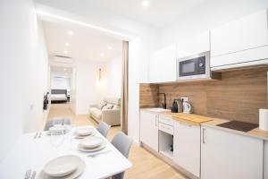 een keuken en woonkamer met een tafel en stoelen bij BedTime Suites by Concept Flats in Valencia +70 foto's