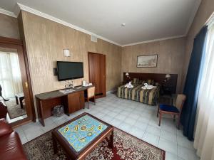 ein Hotelzimmer mit einem Bett und einem Flachbild-TV in der Unterkunft Grand Hotel L'Approdo in Terracina