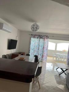 Una sala de estar con mesa y sillas y un comedor. en Villa Cannelle 2, en Étang-Salé