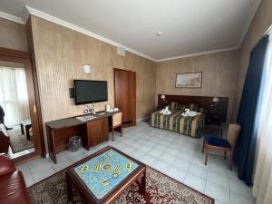 ein Hotelzimmer mit einem Bett und einem TV in der Unterkunft Grand Hotel L'Approdo in Terracina