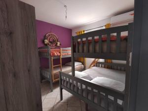 1 dormitorio con 2 literas y paredes moradas en Villa Cannelle 2, en Étang-Salé 24 fotos más