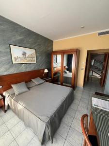 ein Schlafzimmer mit einem großen Bett in einem Zimmer in der Unterkunft Grand Hotel L'Approdo in Terracina