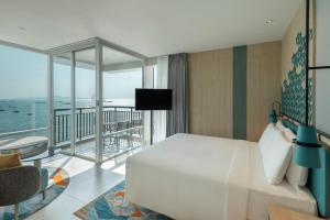 a hotel room with a bed and a balcony at Holiday Inn Pattaya, an IHG Hotel in Pattaya Central