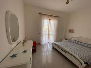 une chambre avec un lit, une commode et un miroir dans l'établissement PIETRA BIANCA, à Acireale