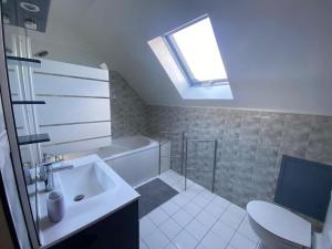 a bathroom with a sink and a toilet and a skylight at House to visit Paris close to Paris, CdG Airport and Villepinte in Aulnay-sous-Bois +13 photos