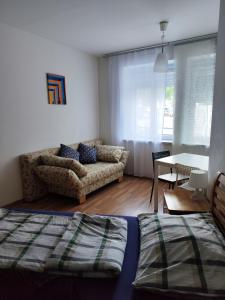 ein Wohnzimmer mit einem Bett, einem Sofa und einem Tisch in der Unterkunft Hostel&ApartServices Viennna The Tidy Apartment in Wien