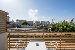 a patio with a table and chairs on a balcony at Ostrakon Suites in Agia Marina Nea Kydonias