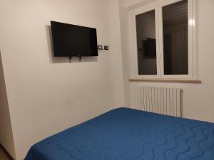 a bedroom with a bed and a tv on the wall at Host4ALL Bixio Cuore di Falconara in Falconara Marittima