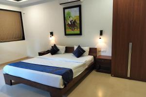 a bedroom with a bed and a picture on the wall at Pegasus Lifestyle Resort Karjat in Karjat