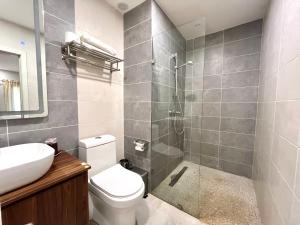 a bathroom with a shower and a toilet and a sink at Forest View Apartments in Kololi