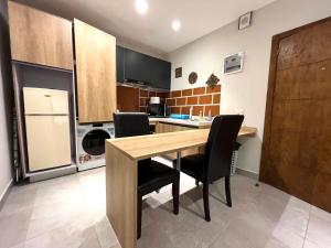 una cucina con tavolo in legno e sedie nere di Forest View Apartments a Kololi
