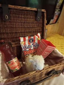 a basket with food and a stuffed animal in it at 'Morris' the shepherd's hut with woodland hot tub in Carmarthen
