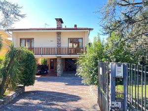 una casa con balcone e cancello di Villa Anna with pool and lift a Capannori