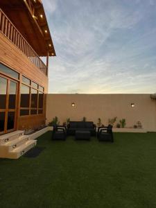 a patio with a couch and some green grass at اكواخ وشاليهات لوزان الريفية 2 in Dahaban