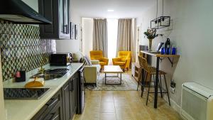 cocina con fregadero y sala de estar. en Apartamentos Puente Romano Suites Parking Gratis, en Mérida