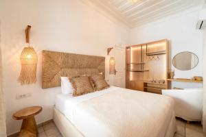 a white bedroom with a bed and a table at Villa Antonis in Halki