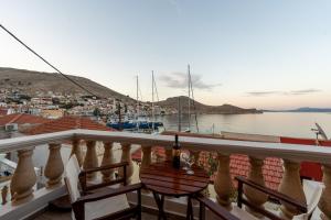a balcony with a table and chairs overlooking a harbor at Villa Antonis in Halki